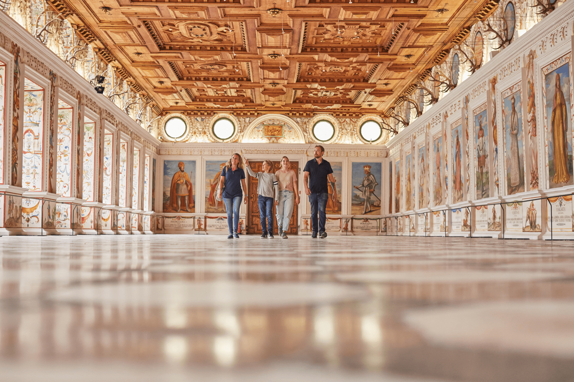 Besucher gehen durch einen Saal in der Hofburg.