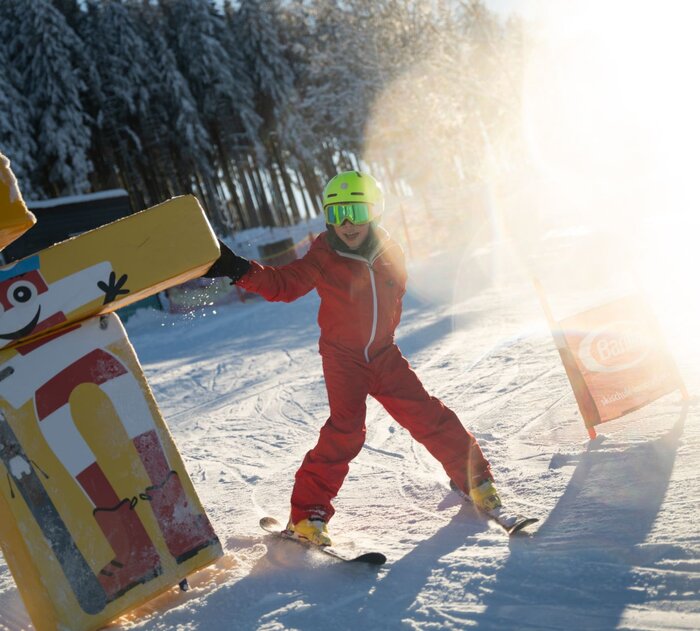 Ein Kind fährt auf einer Kinderpiste.