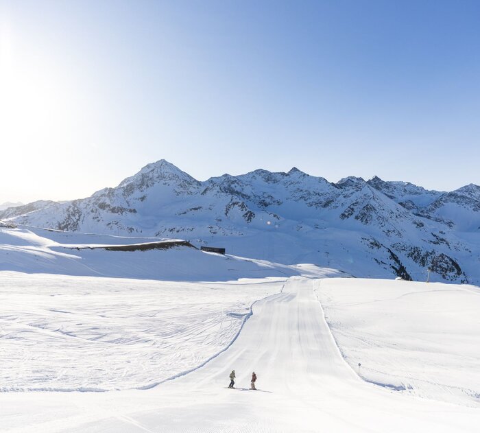 Zwei Personen umgeben von einer verschneiten Landschaft.
