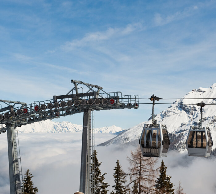 Gondelbahnen umgeben von einer nebligen Winterlandschaft.