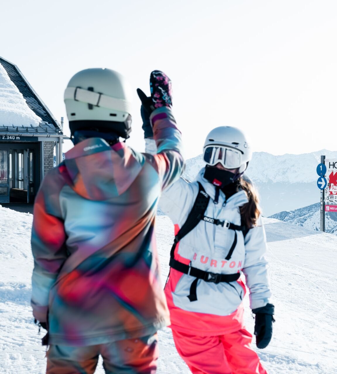 Zwei Personen in Skikleidung geben sich ein High-Five.